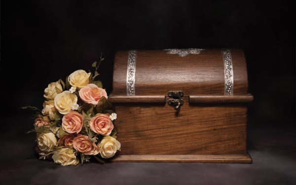 Conservazione ceneri defunti Milano: urna di cenere con un mazzo di fiori affianco
