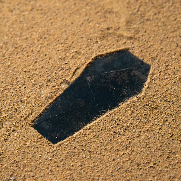 Sepoltura in Mare: silhouette di cofano sulla sabbia